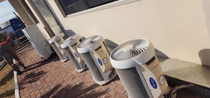 Engenheira técnica realizando auditoria e laudo PMOC em sistema comercial de ar condicionado